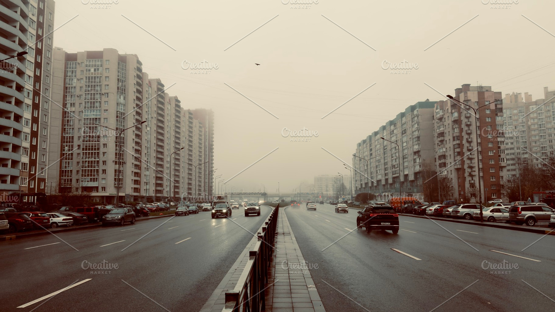 A wide urban road lined with tall residential buildings, cars driving under a c, an Industrial Photo by Textures & Backgrounds