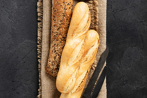 Assorted Baguettes on Burlap with Rustic Knife and Dark Backgrou, a Food & Drink Photo by Natalia Klenova's Shop