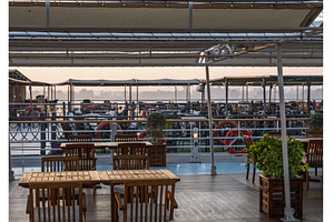 Sun rises over the tables on deck of, a Nature Photo by Backyard Stock