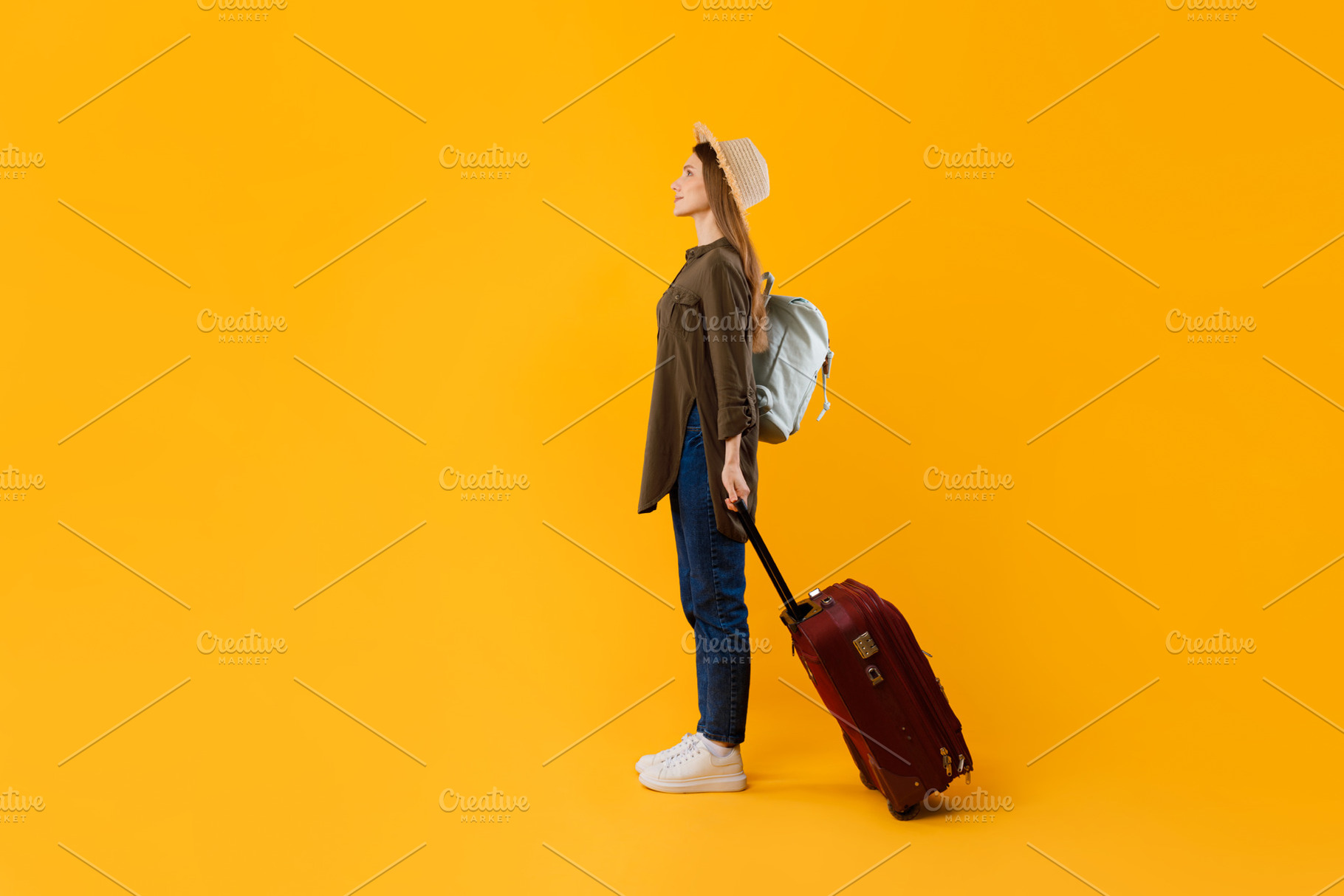 Female Tourist With Suitcase And Luggage Standing Over Yellow Background, a Photo by Prostock-Studio