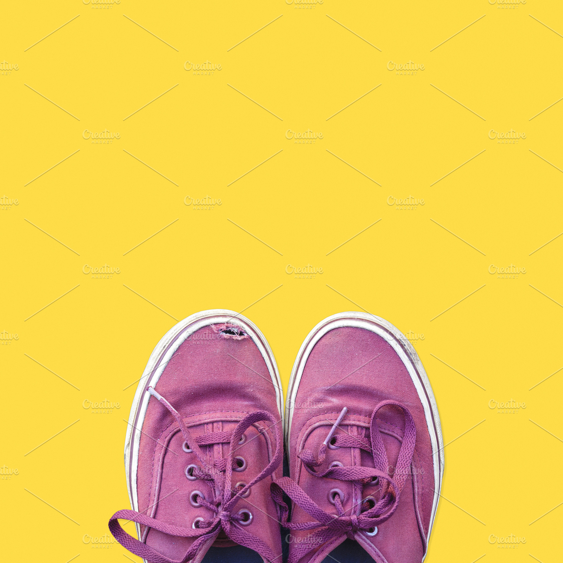 Old sneakers on yellow background, a Beauty & Fashion Photo by BOOCYS