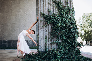 Woman dancing gracefully against ivy, a Person Photo by Anna Efetova