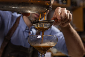 Bartender pouring espresso martini cocktail, a Photo by Grafvision photography