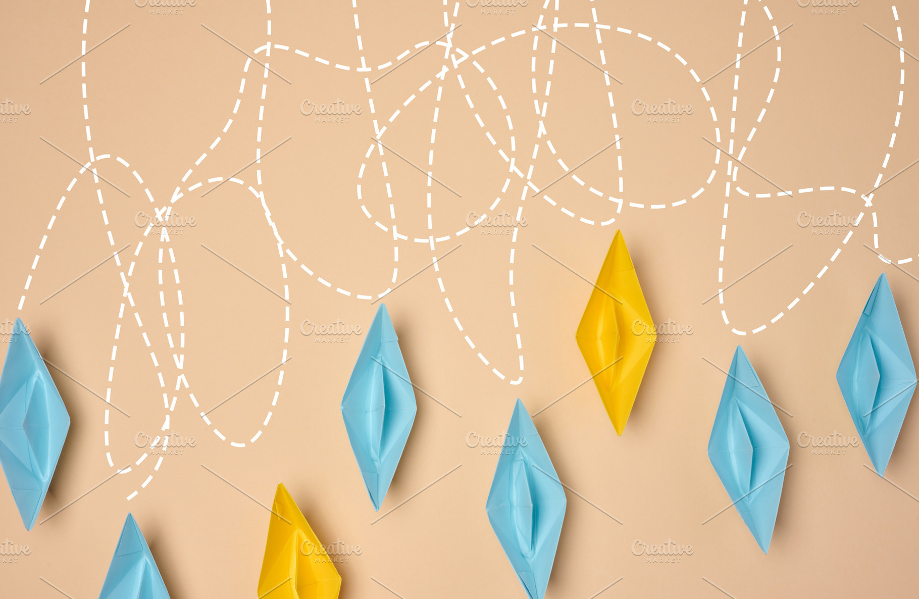 A creative composition featuring blue and yellow paper boats wit, a Business Photo by ndanko