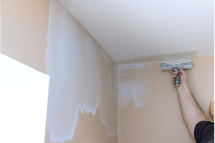Plasterer smoothing wall surface, an Industrial Photo by Ungvar Studio