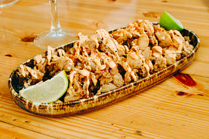fried chipirones with lime on a wooden table, a Photo by Nito