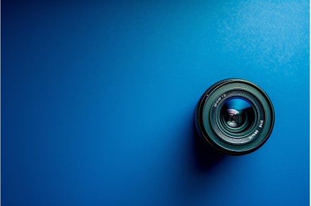 Camera lens on blue background, a Technology Photo by Ylivdesign