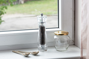Empty spice jars and pepper mill on a windowsill, an Industrial Photo by MDBildes