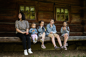 Family enjoying time together in front of a rustic wooden building, a Person Photo by AS photostudio