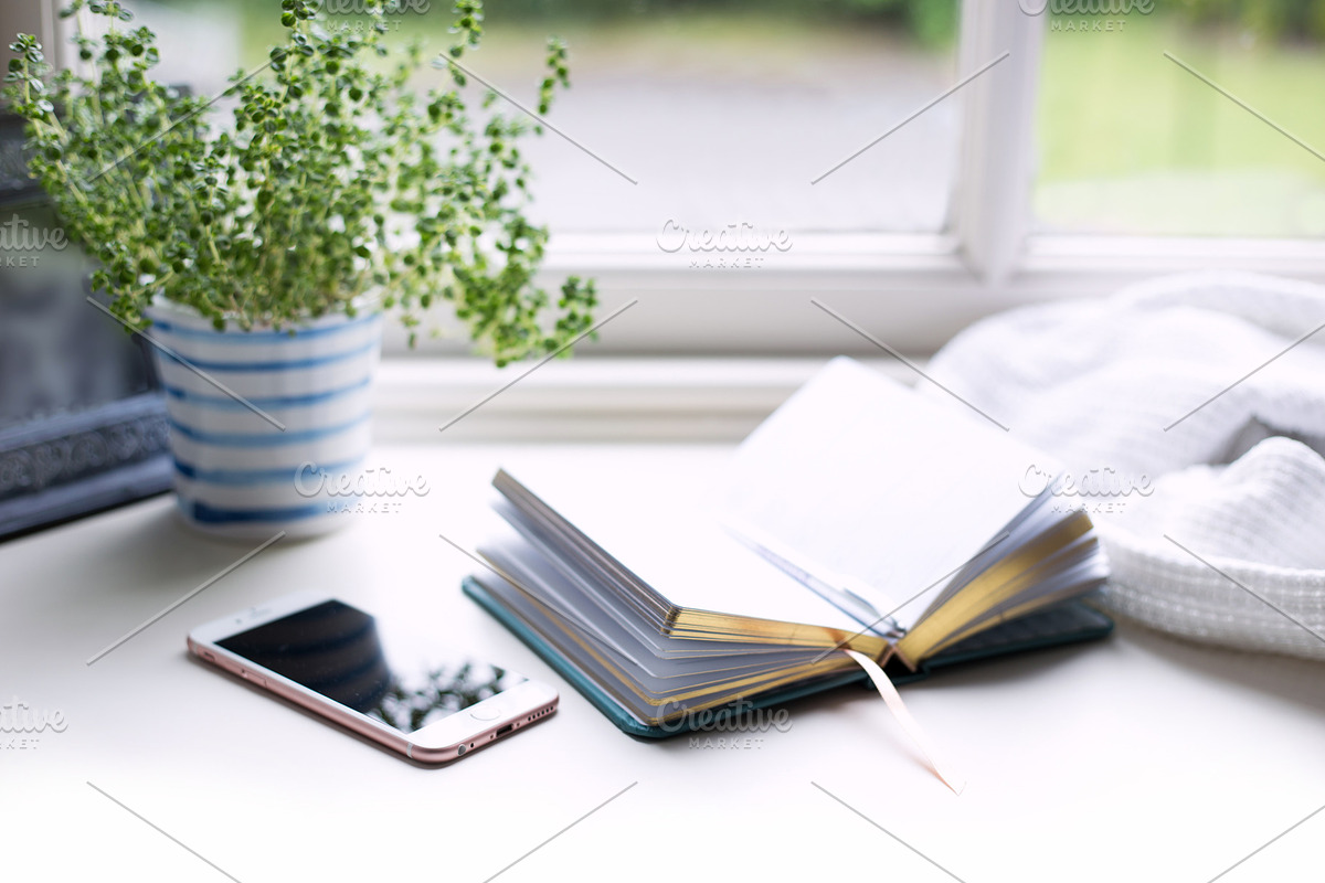 Phone and book at window, a Business Photo by the studio louvain shop (Photo 2 of 2)