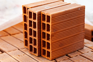 Close up of hollow bricks resting on wooden pallet during building construction, an Industrial Photo by Antonio Gravante Market