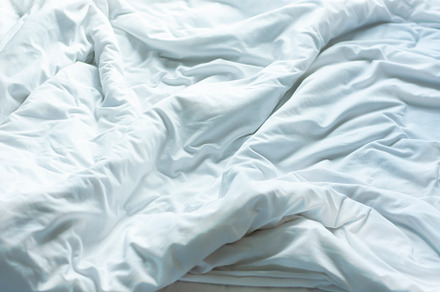 White sheets, wrinkled duvets.