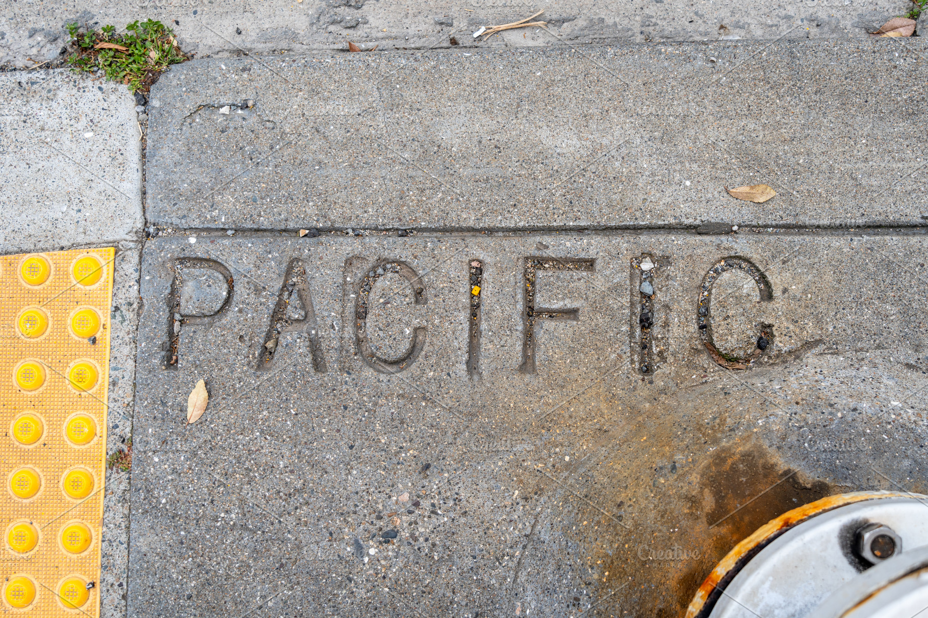 Engraved Pacific text on a weathered sidewalk in San Francisco, an Abstract Photo by GoodGoods