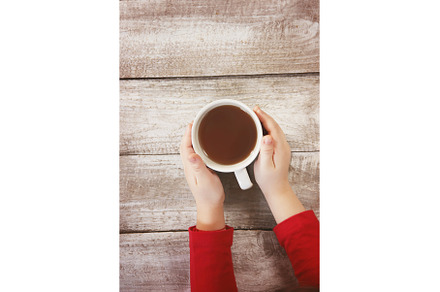 A cup of tea in the hands of a child, a Food & Drink Photo by yanadjana