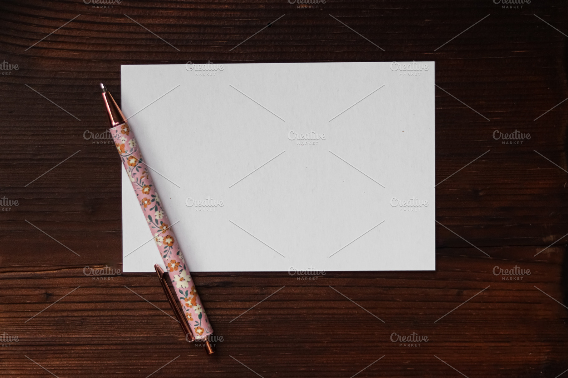 Blank white card with floral pen on wooden background, creating a ready to writ, a Photo by Studio ANNA