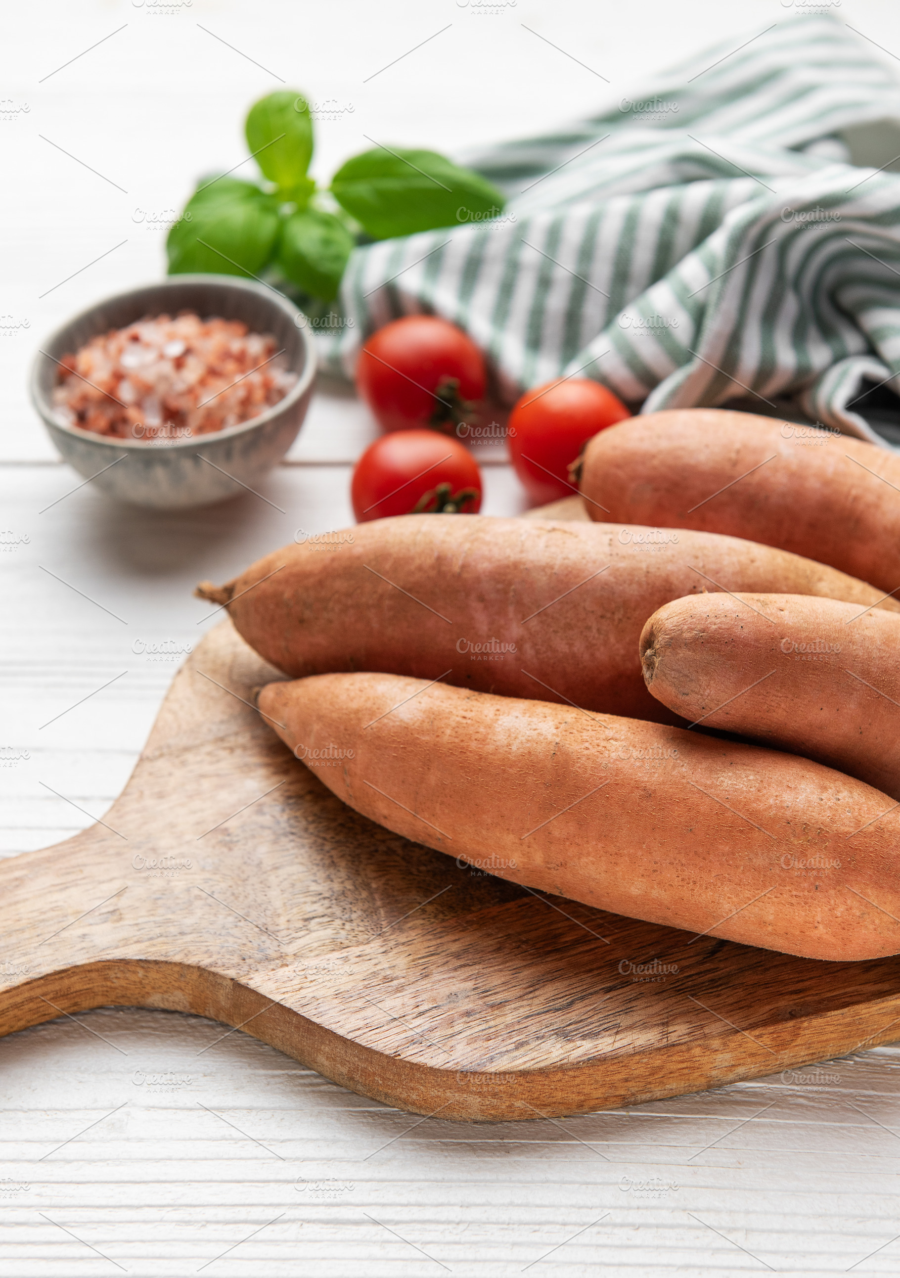 Sweet potatoes on cutting board with kitchen ingredients, a Food & Drink Photo by Olena Rudo