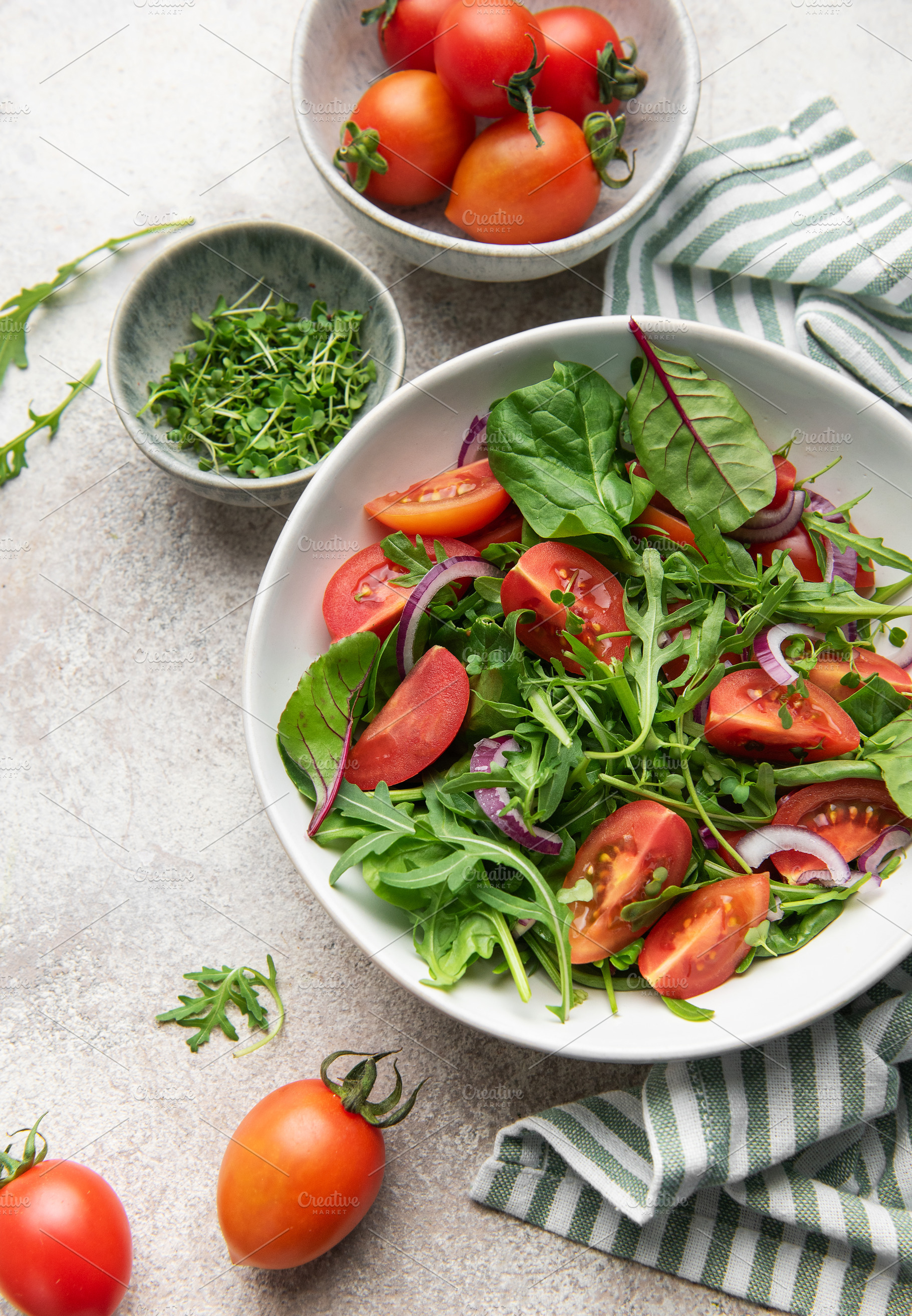 Fresh green salad with tomatoes and red onion, a Food & Drink Photo by Olena Rudo
