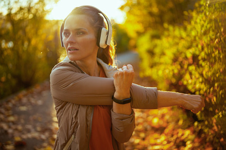 stylish woman in fitness clothes in park stretching, a Sports & Recreation Photo by Alliance Images