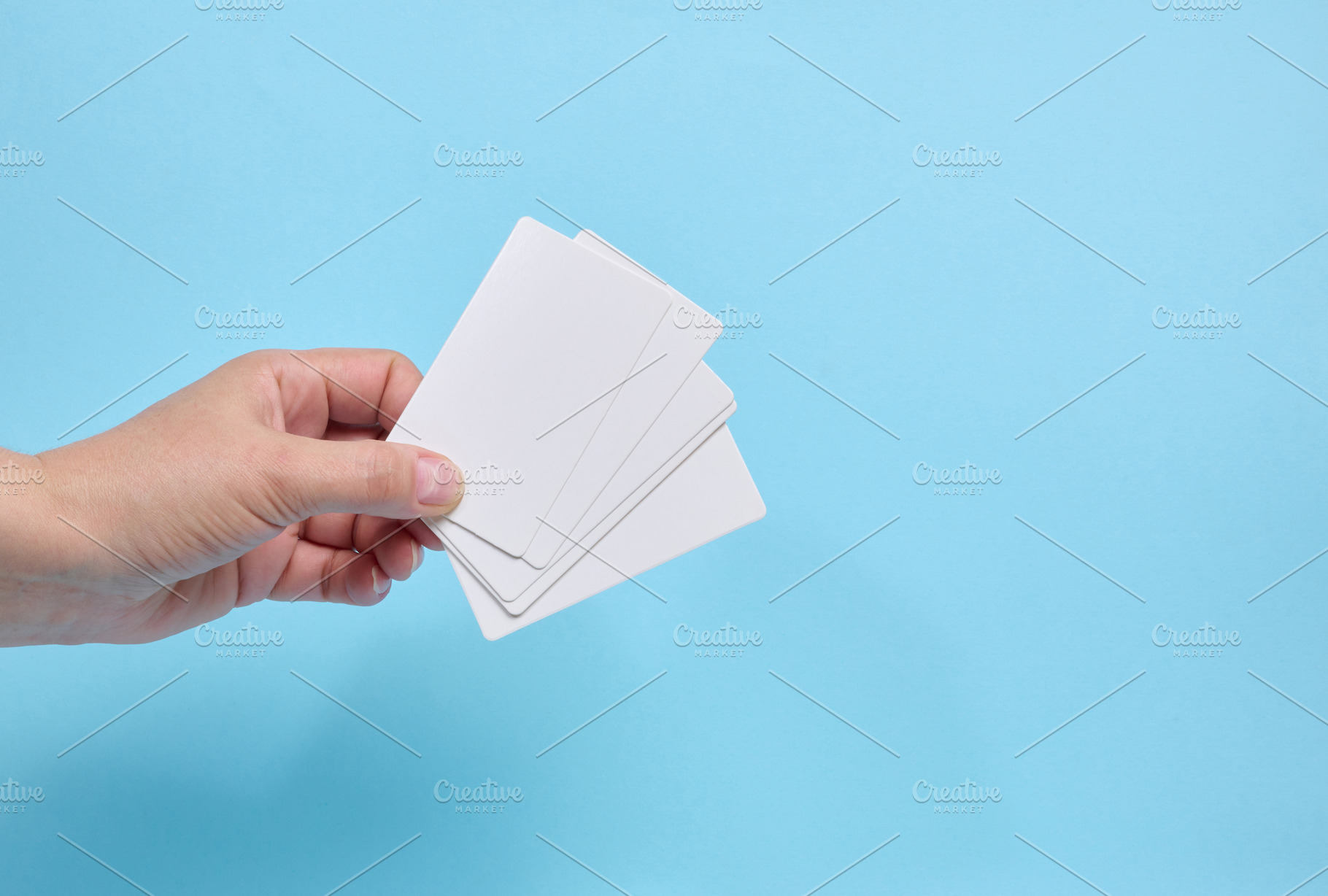 A person holding a fan of blank white business cards against a b, a Business Photo by ndanko