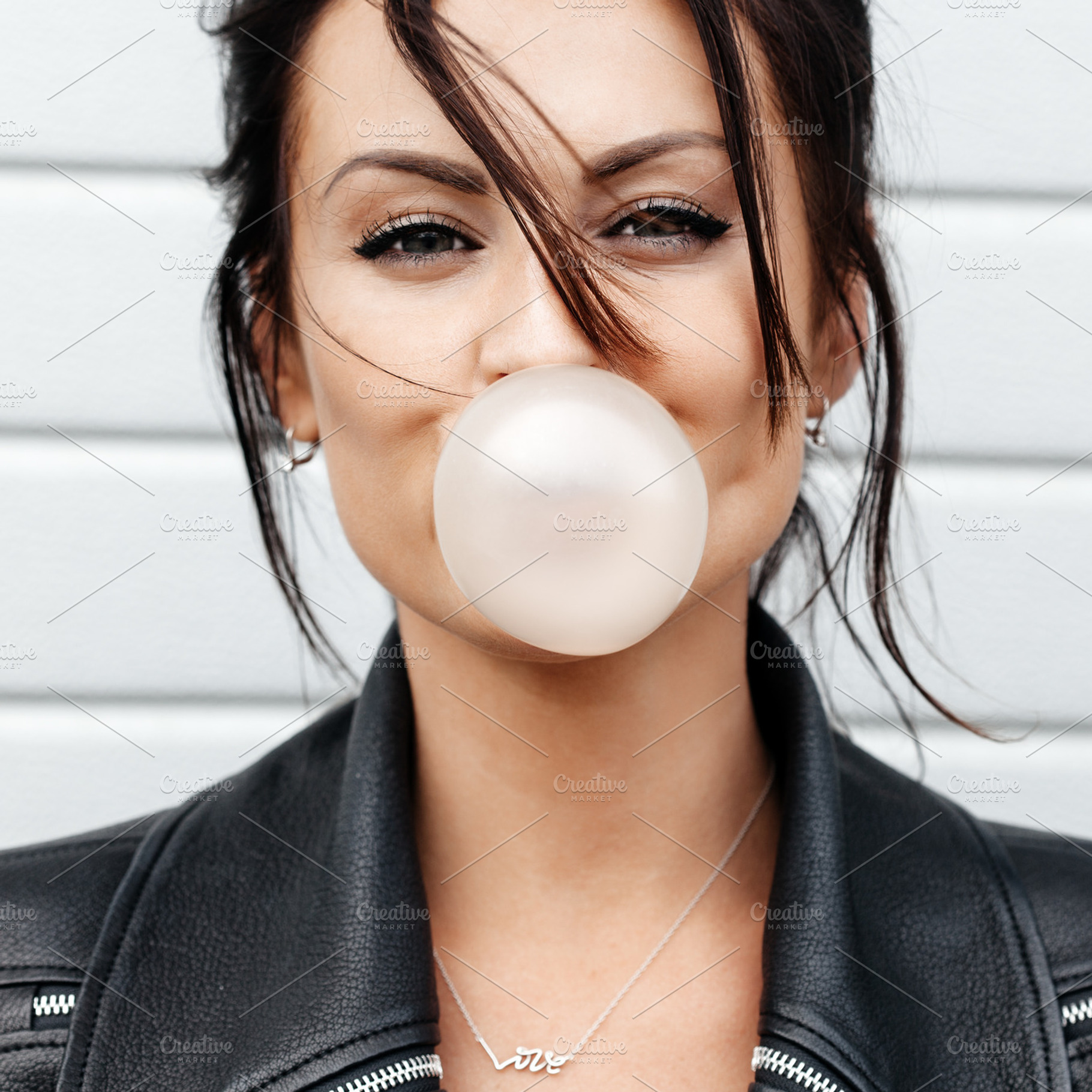 Beautiful young woman blowing a bubble gum balloon, a Person Photo by Aliaksei Kaponia