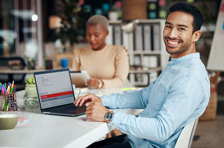Portrait, smile and business man in office with pride for career, occupation or job. Ceo, boss and happy, proud or confident Asian professional entrepreneur sitting at table with laptop in company., a Photo by Peopleimages.com