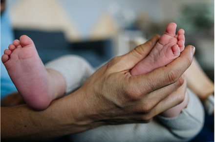 Dad holding little baby boy's feet., a Person Photo by HalfPoint