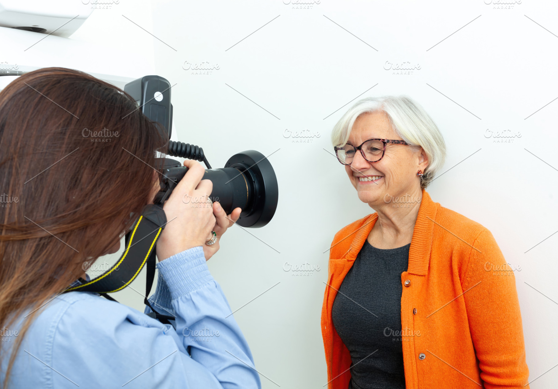Photographer taking pictures of a smiling senior woman in a studio, a Health & Medical Photo by Antonio Gravante Market