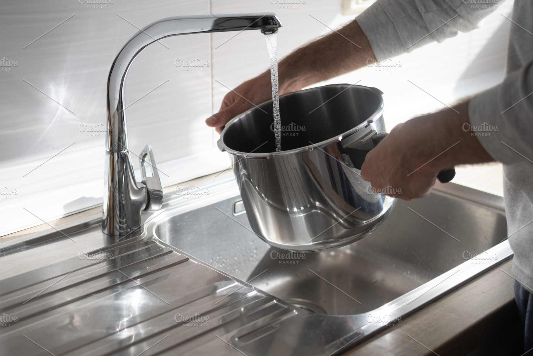 Filling pot with water from kitchen faucet over stainless steel sink, a Food & Drink Photo by etorres69