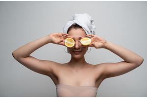 Woman with towel holding lemon, a Health & Medical Photo by volodymyrshtun13795