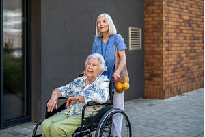 Home caregiver assisting older woman, a Food & Drink Photo by HalfPoint