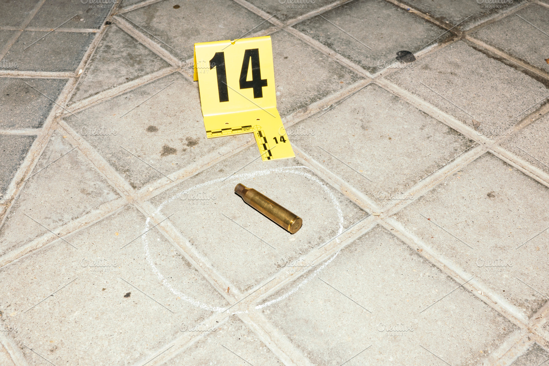Bullet casing marked as evidence at crime scene, an Industrial Photo by karrastock