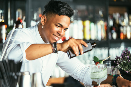 Smiling bartender serving cocktail