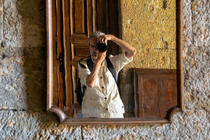 Man photographing a rustic stone wall mirror, an Animal Photo by DanFLCreativo