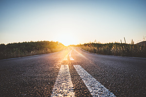 Asphalt road in mountains at sunset featuring road, sunset, and highway