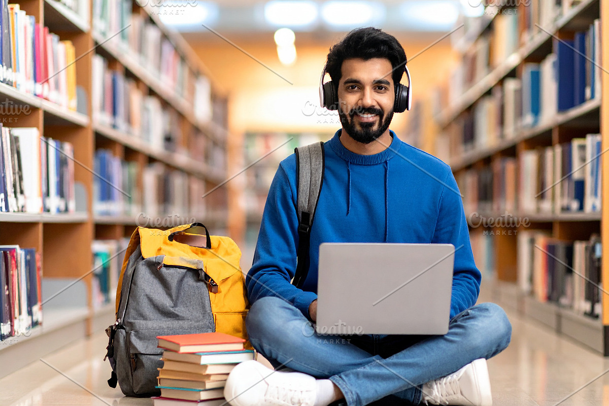 Student on the floor surrounded by notebooks, headphones, coffee, a School & Education Photo by DanFLCreativo (Photo 2 of 2)