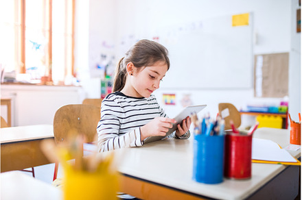 Portrait of cute schoolgirl sitting, a School & Education Photo by HalfPoint
