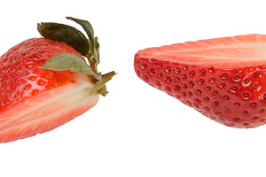 Halves of red ripe strawberries with green sepals on isolated ba, a Food & Drink Photo by ndanko