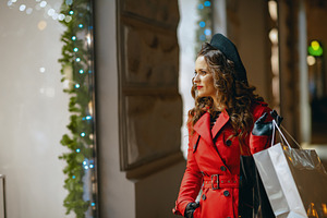 female shopper looking at shop window outdoors in city at night, a Person Photo by Alliance Images