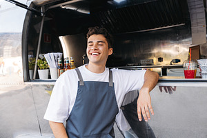 Cheerful food truck owner, a Person Photo by Artem Varnitsin