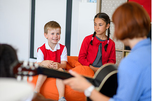 School kids and teacher with guitar, a Person Photo by HalfPoint