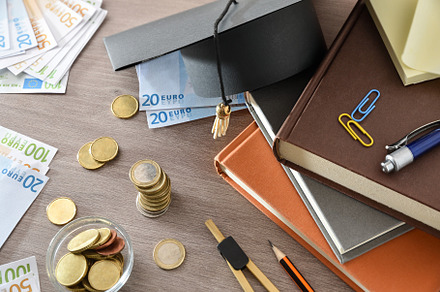 Education spending concept with books and money top view