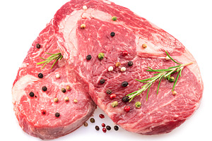 Two fresh ribeye steaks with peppercorn and rosemary isolated on, a Food & Drink Photo by Volff