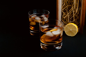 Whiskey glasses containing alcohol, ashtray, and background