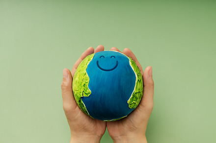 Happy Earth in hands symbolizing sustainability, global happines