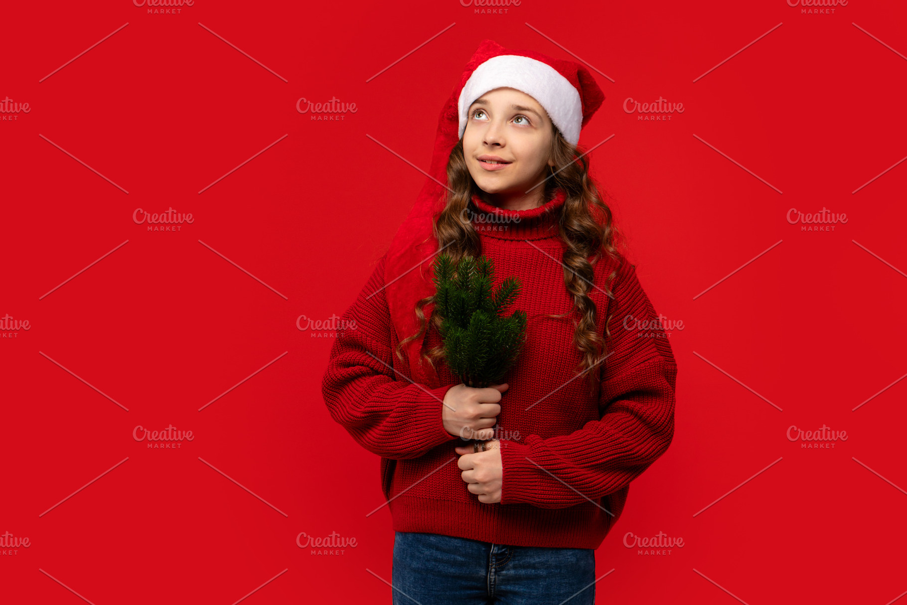 Teen girl in Santa hat holding small, a Holiday Photo by Elena Vagengeim