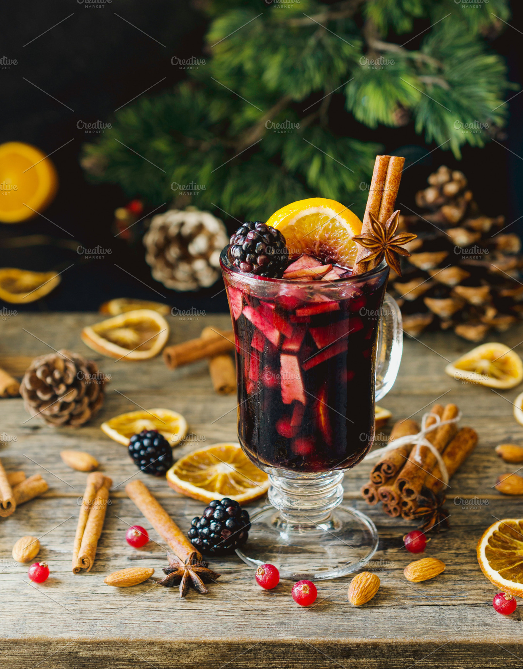 Glass of hot mulled wine for the new year with ingredients for cooking nuts, a Food & Drink Photo by Wild Drago Shop