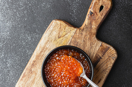 Salmon caviar on a wooden board