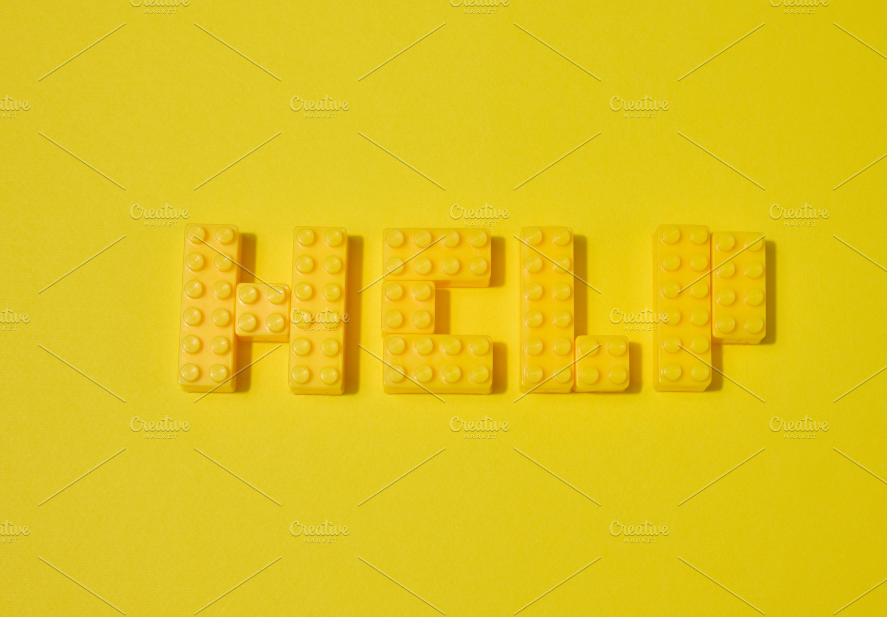 The word HELP, made from yellow toy blocks, is placed on a yello, an Abstract Photo by ndanko