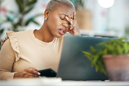 Stress, headache and black woman in the office while working on project with a laptop. Burn out, tired and professional African female business employee with a migraine in modern corporate workplace., a Photo by Peopleimages.com