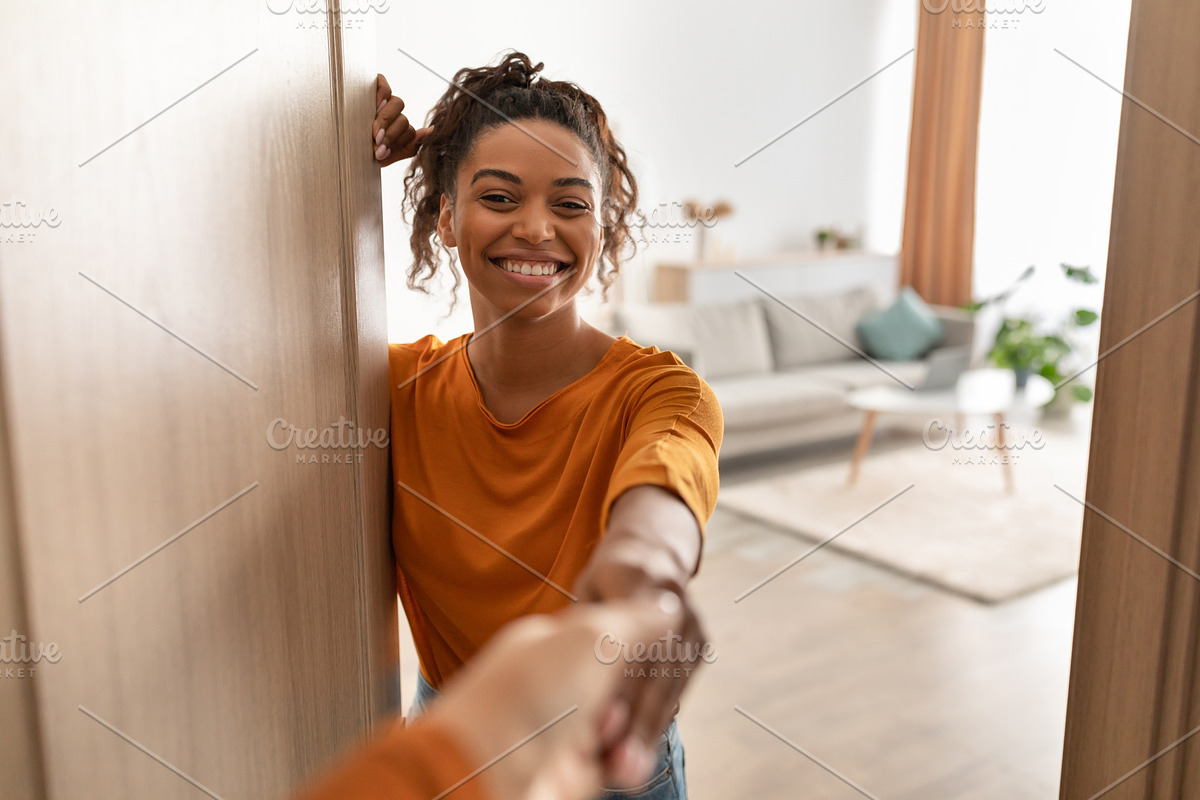 Cheerful African Woman Shaking Hands In Opened Door At Home, a Photo by Prostock-Studio (Photo 1 of 3)